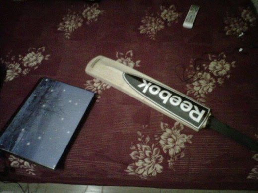 A Reebok cricket bat and a book from college days