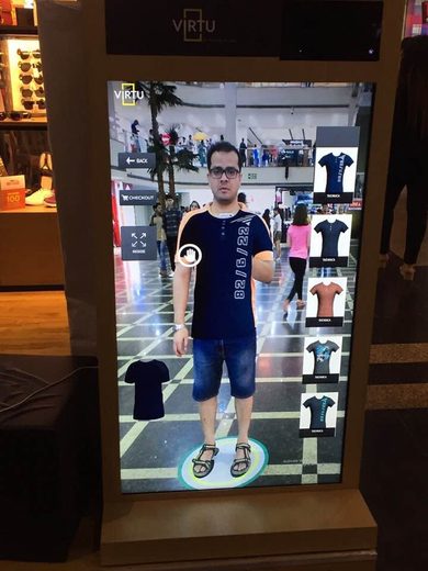 Mahabir using a virtual try-on mirror at a mall in 2018